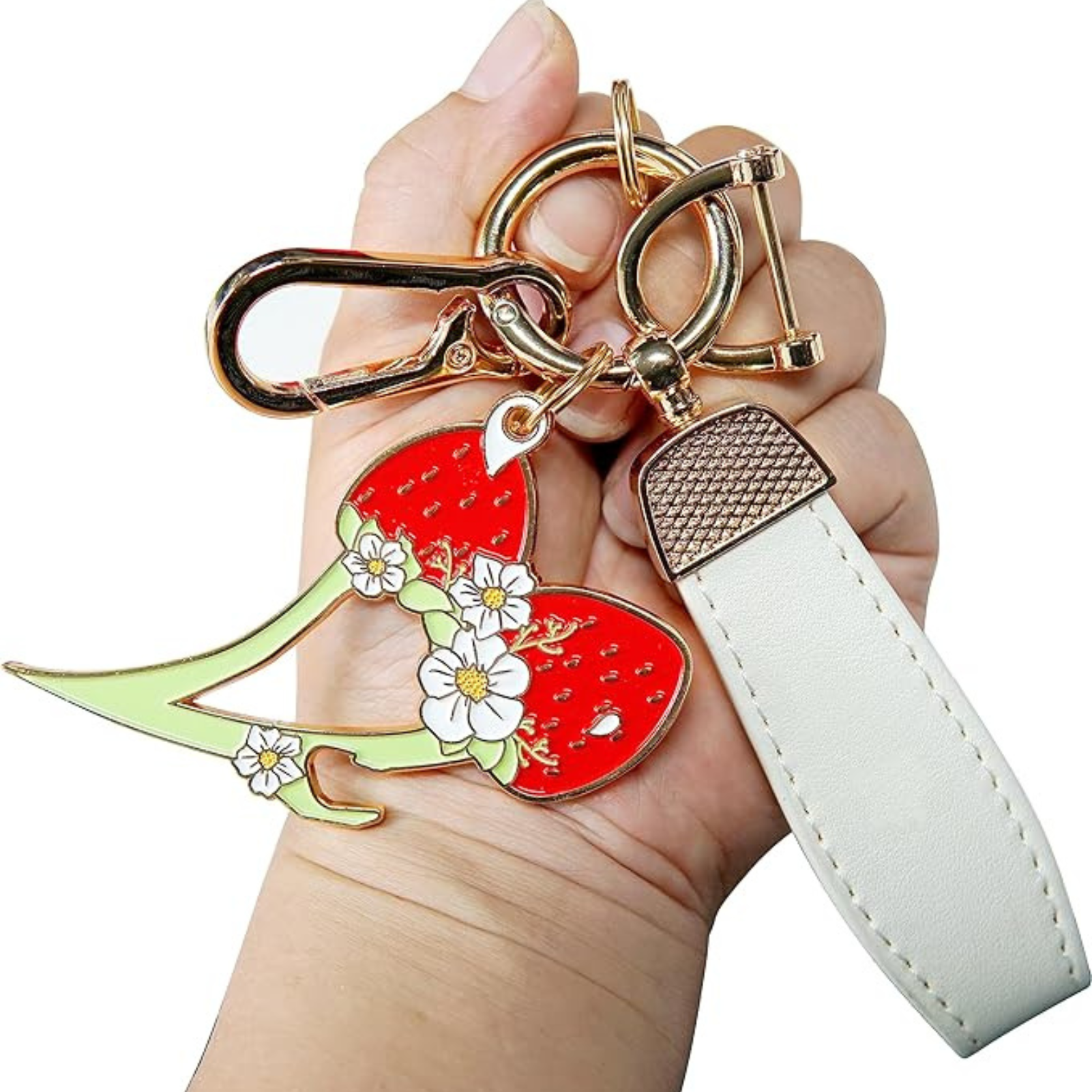Keychain with strawberry design held by a hand on a white background